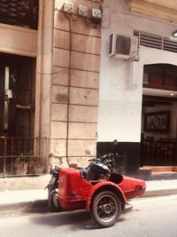 Vintage car on street against buildings in city