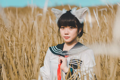 Portrait of young woman standing on field