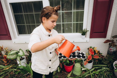 Girl watering plants from a watering can
