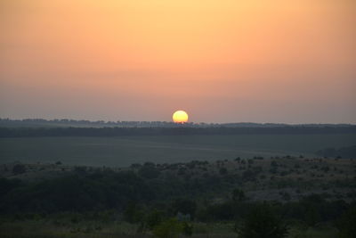 Scenic view of field against sky during sunset