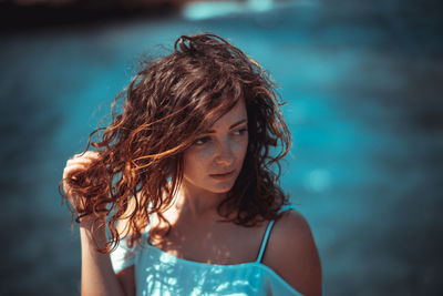 Close-up of beautiful young woman against sea