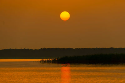 Scenic view of lake against sky during sunset
