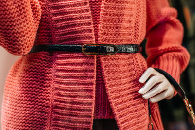 Fancy details of a pink knitted cardigan with leather black belt. women's fashion clothing