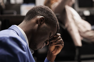 Side view of young man looking at the dark