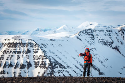 Woman standing with skis with mountains behind in iceland