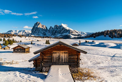 House on snowcapped mountain against sky