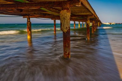 Wooden pier on sea against sky