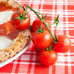 Close-up of cherry tomatoes by pizza on table