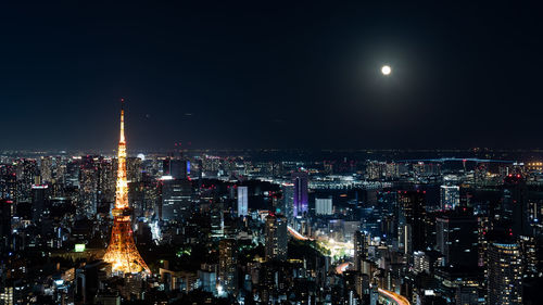 Illuminated cityscape against sky at night