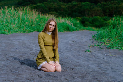 Portrait of smiling young woman standing on sand