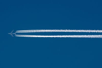 Low angle view of vapor trail against blue sky