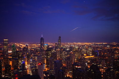 Aerial view of illuminated buildings in city at night