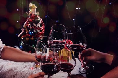 Cropped hands of friends toasting drink during christmas celebration