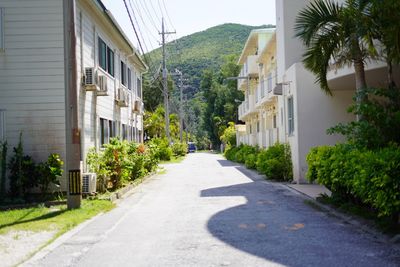 Empty road by buildings in city