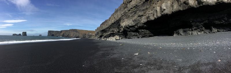 Rock formations on beach against sky