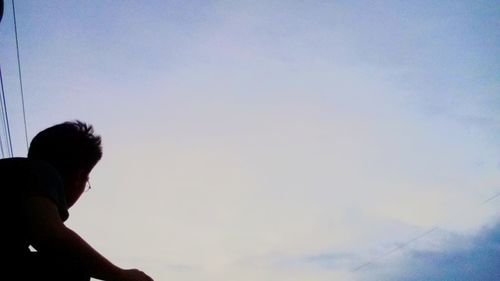 Low angle view of woman standing against clear sky