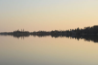 Scenic view of lake against clear sky during sunset