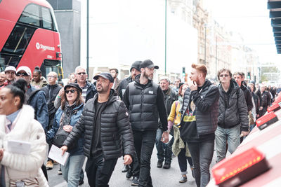 Group of people walking on street in city