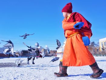 People flying birds against blue sky