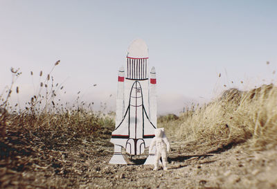 Close-up of astronaut figurine with rocket toy on field