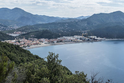 Scenic view of townscape by mountains against sky