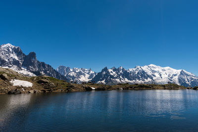 Scenic view of snowcapped mountains against blue sky