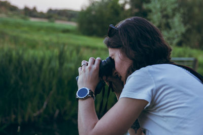 Side view of woman holding dog on field