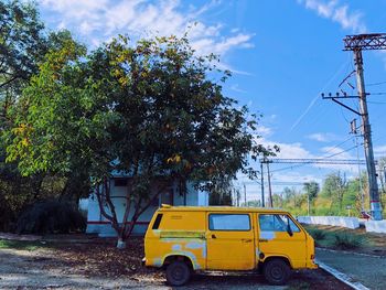 Yellow car on road against sky