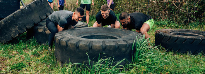 People lifting tire outdoors