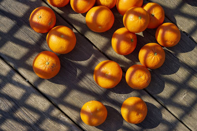 Close-up of orange fruits on table with shadow