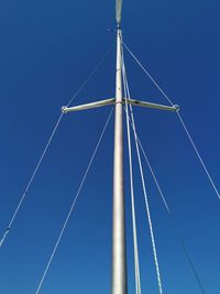 Low angle view of sailboat against clear blue sky