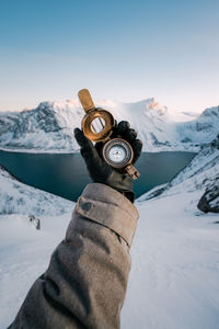 Cropped hand of person holding navigational compass