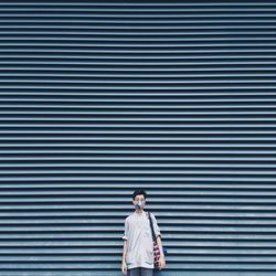 Portrait of man standing against wall