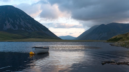 Scenic view of lake by mountains against sky