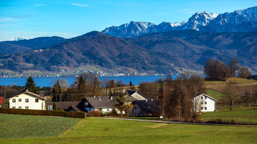 Houses on field by mountains against sky