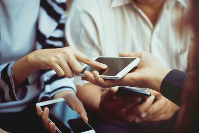 Midsection of man using mobile phone