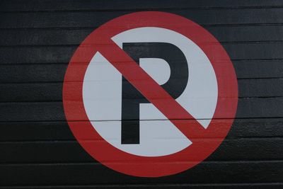 Close-up of no parking sign on wall