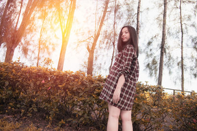 Full length of woman standing in forest