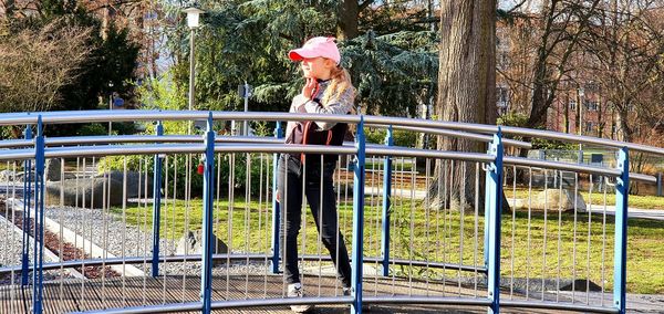 Woman standing by railing in park