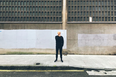 Full length of a man standing against wall