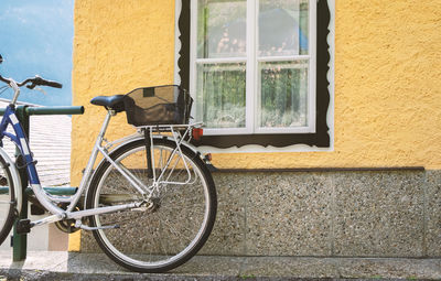 Bicycle against yellow wall of building