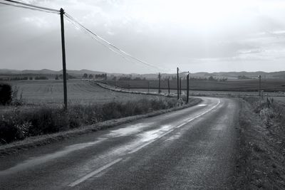 Road by field against sky