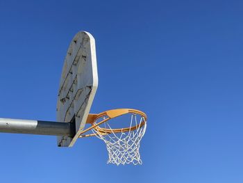 Low angle view of basketball hoop against clear blue sky