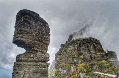 Low angle view of rock formation against sky