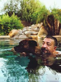 Man with dog swimming in lake