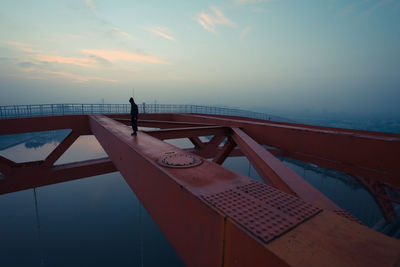 Silhouette of woman against cloudy sky