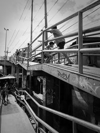 Children at footbridge against sky