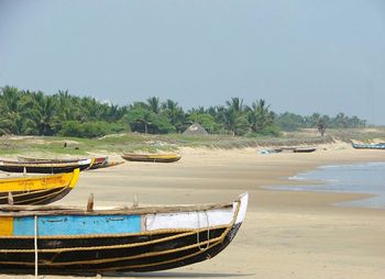 Boats moored on shore against sky