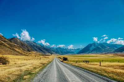 Road amidst field against sky