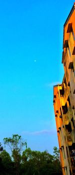 Low angle view of buildings against clear blue sky